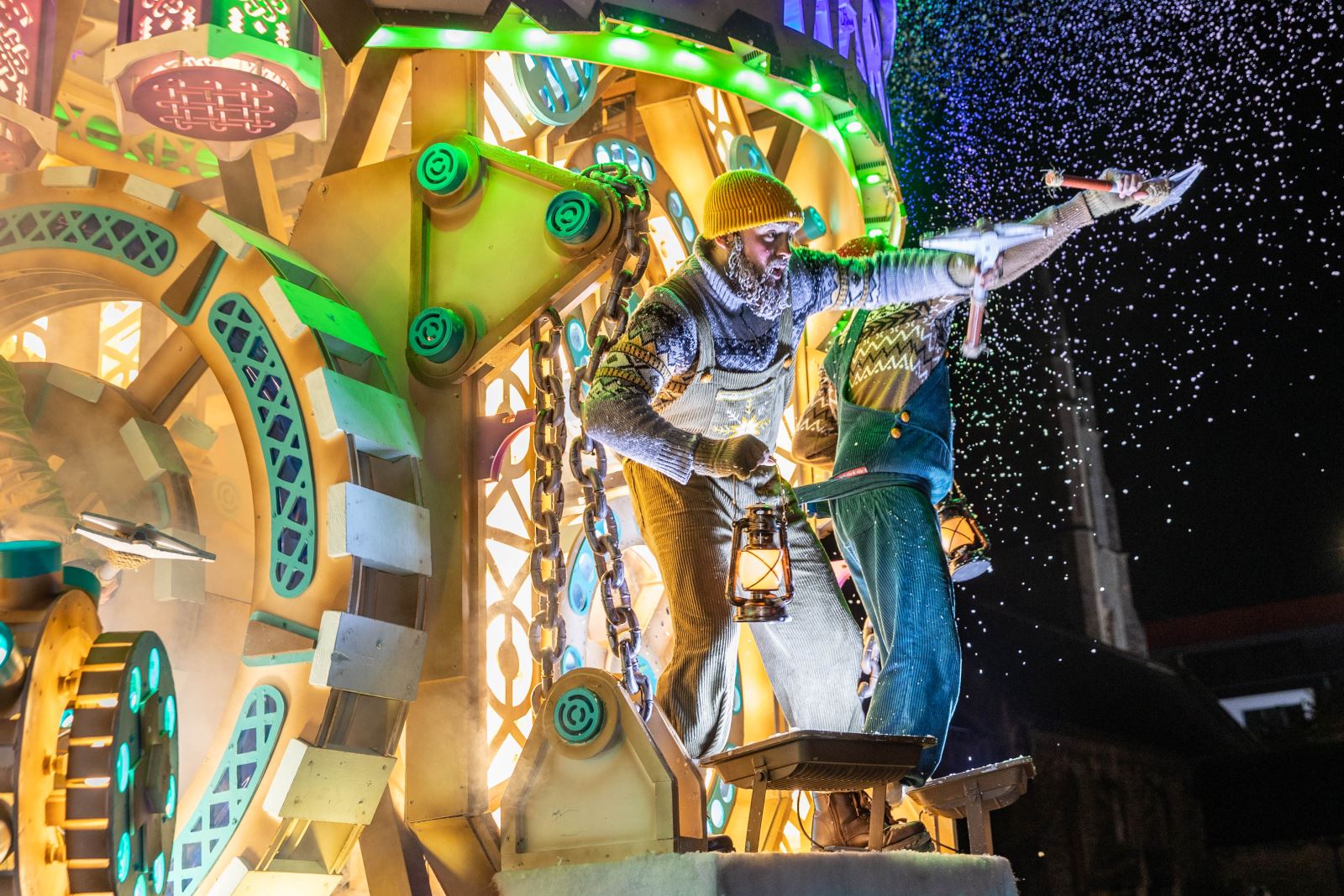 An extravagant ice themed carnival cart at the Weston-super-Mare Carnival with a performer at the front holding an ice pick as fake snow pumps out into the sky